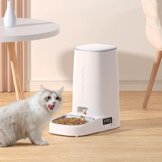 Distributeur croquettes chat blanc avec écran digital et chat à poils longs mangeant dans une gamelle