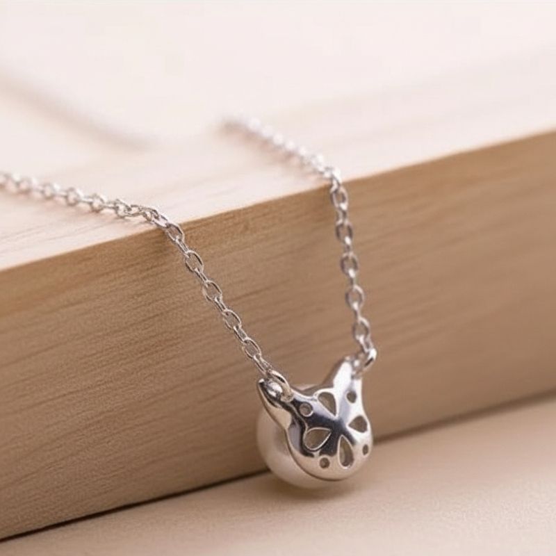 collier pendentif chat avec perle argent sur bloc bois